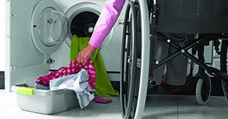 person in a wheelchair doing laundry