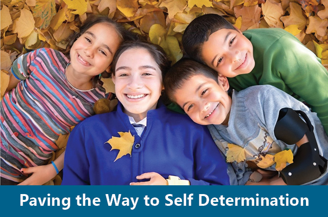 Four children with apparent and non-apparent disabilities laying in a pile of autumn leaves. Text "Paving the Way to Self Determination."