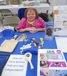 woman behind a table with assistive technology information