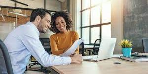 Man and Woman looking at a paper and laptop.