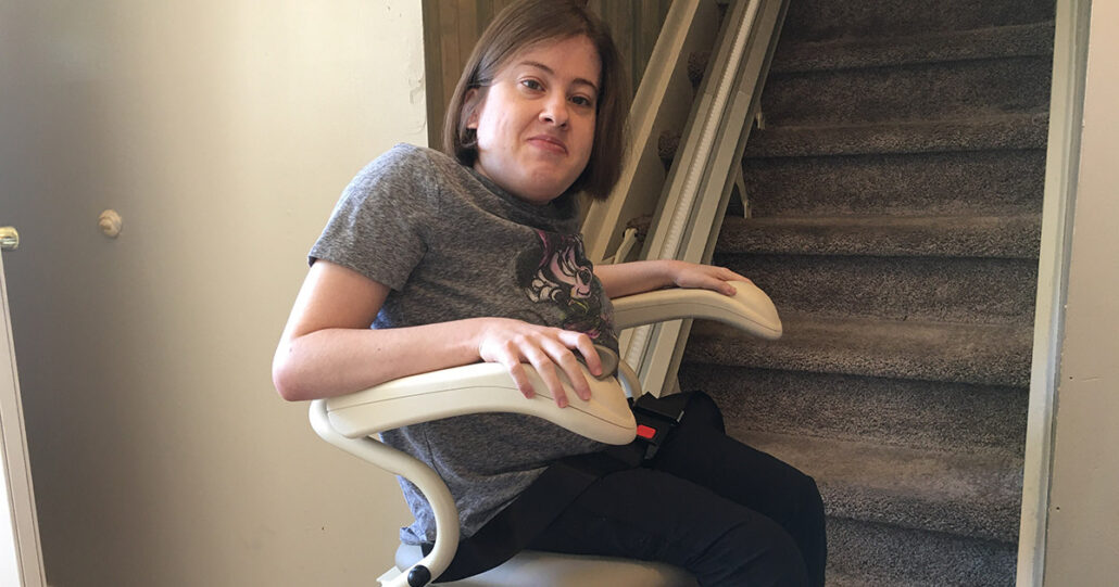 Image of woman with a disability using a stair assist chair.